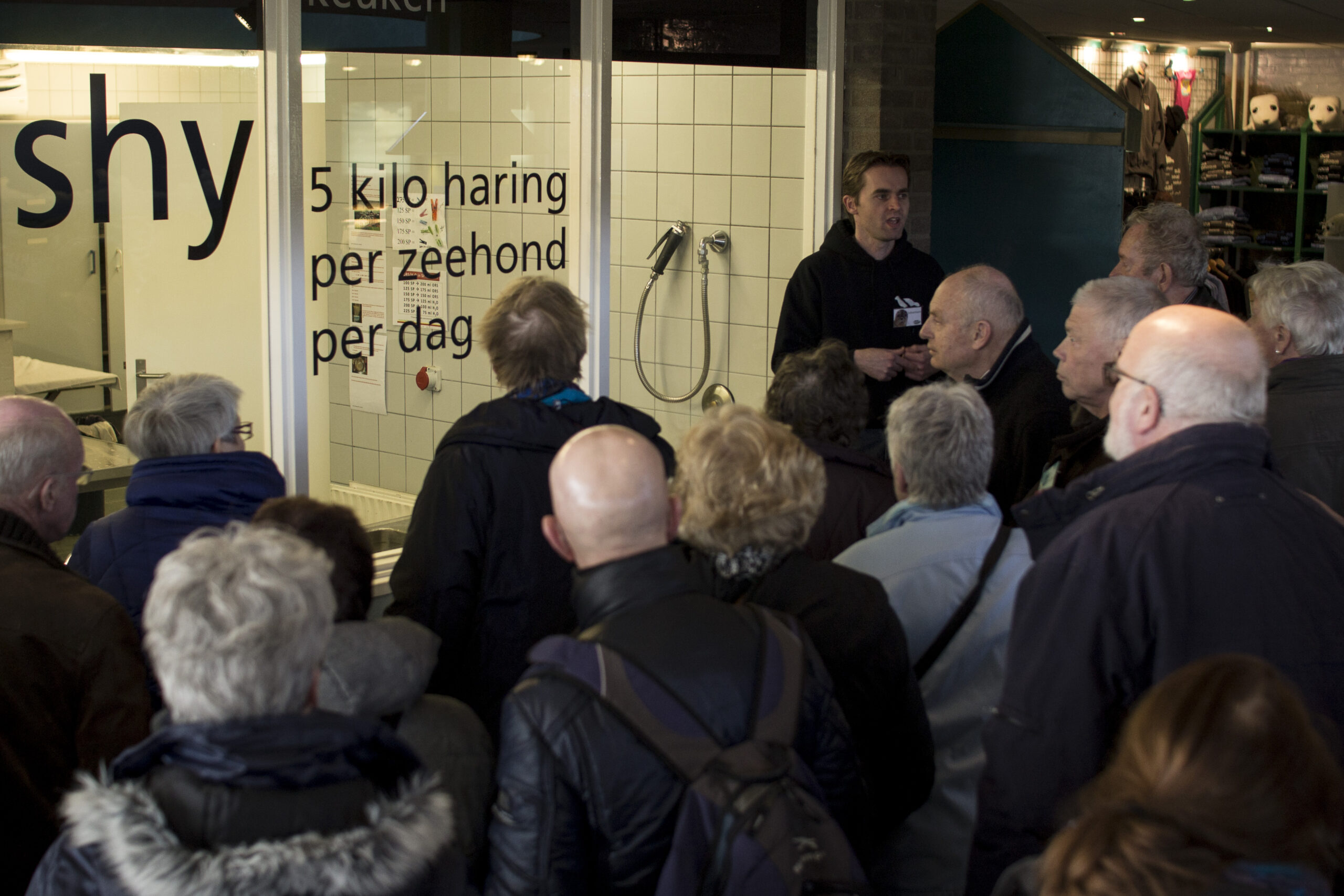 Medewerker Zeehondencentrum geeft informatie aan bezoekers bij viskeuken