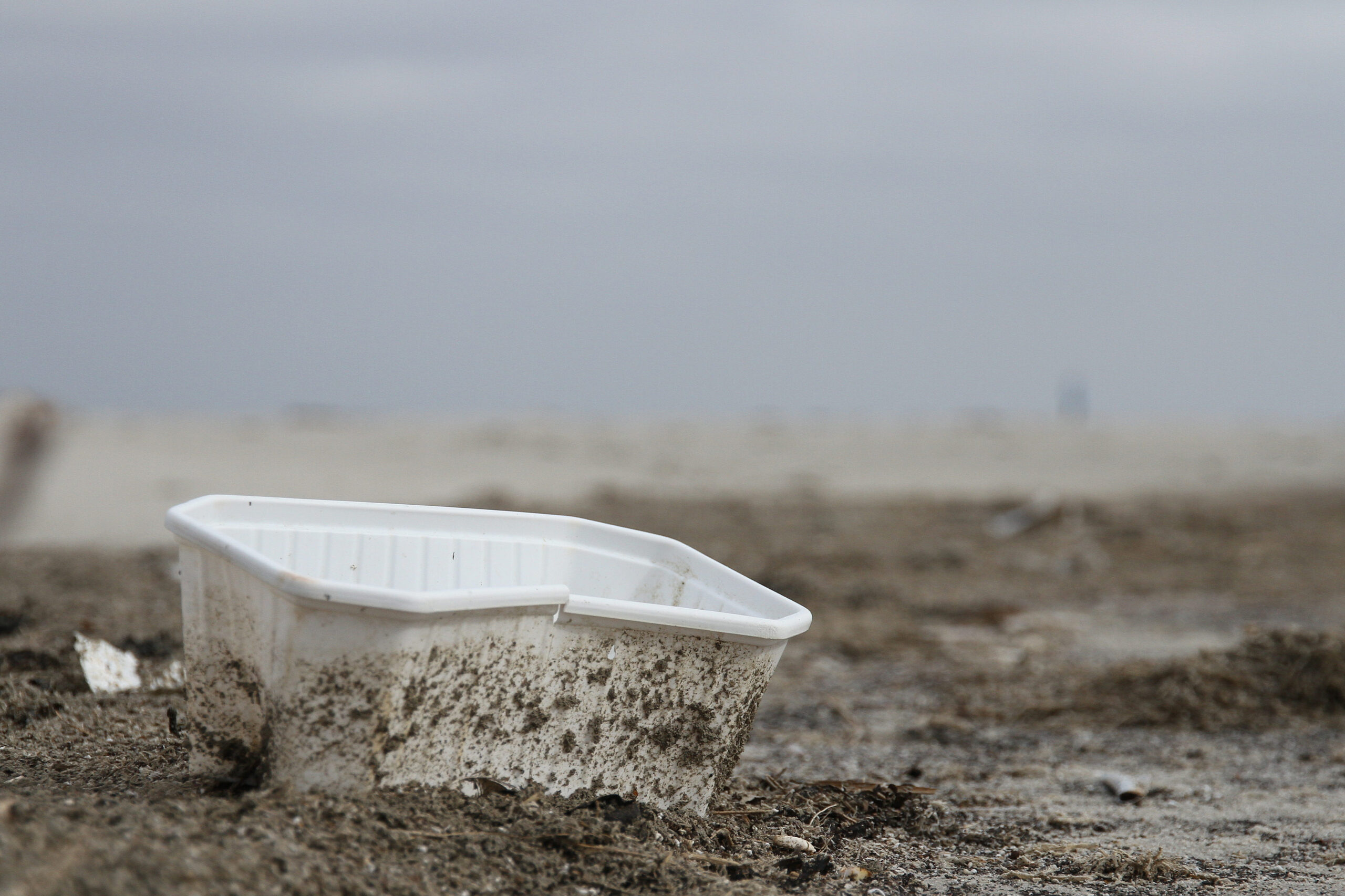 plastic bakje op strand